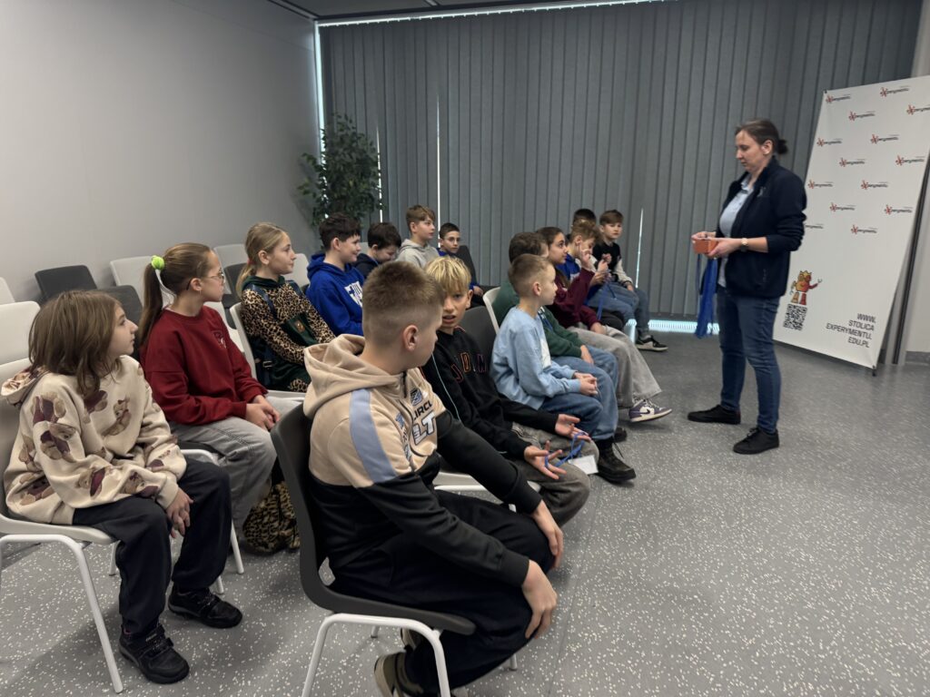 Grupa dzieci i dorosła kobieta rozmawiający ze sobą