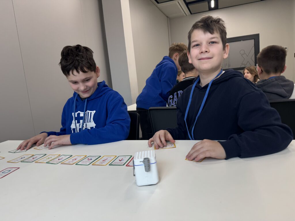 dwoje dzieci bawiących się robotem.